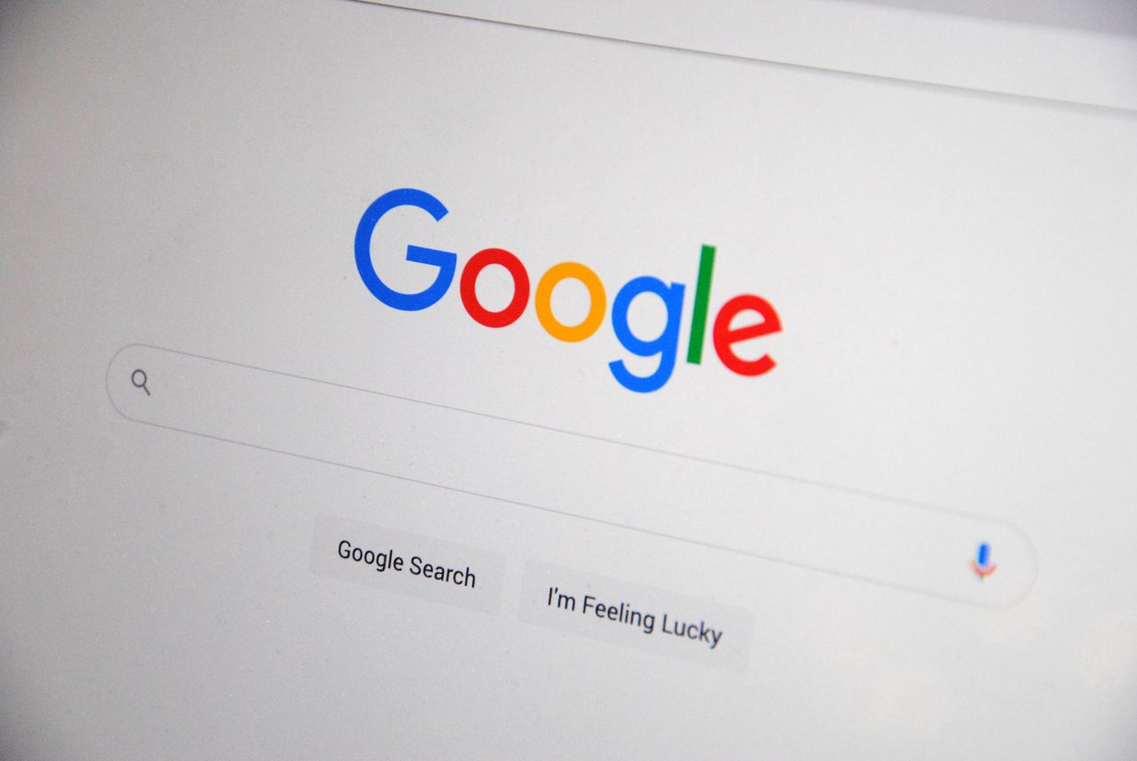 services-01 Close-up of the Google homepage on a screen showing search options.